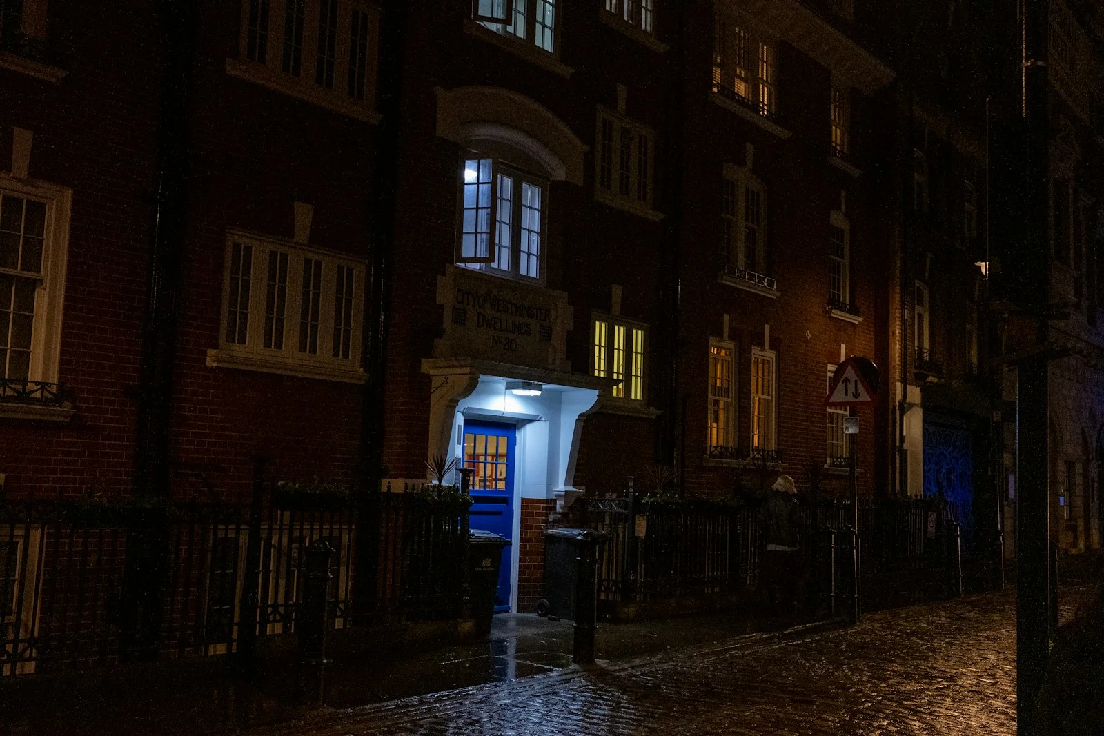 a dark city street at night with a blue door a dark city street at night with a blue door