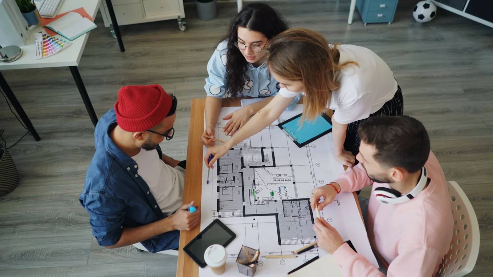 a group of people sitting around a table working on a project a group of people sitting around a table working on a project