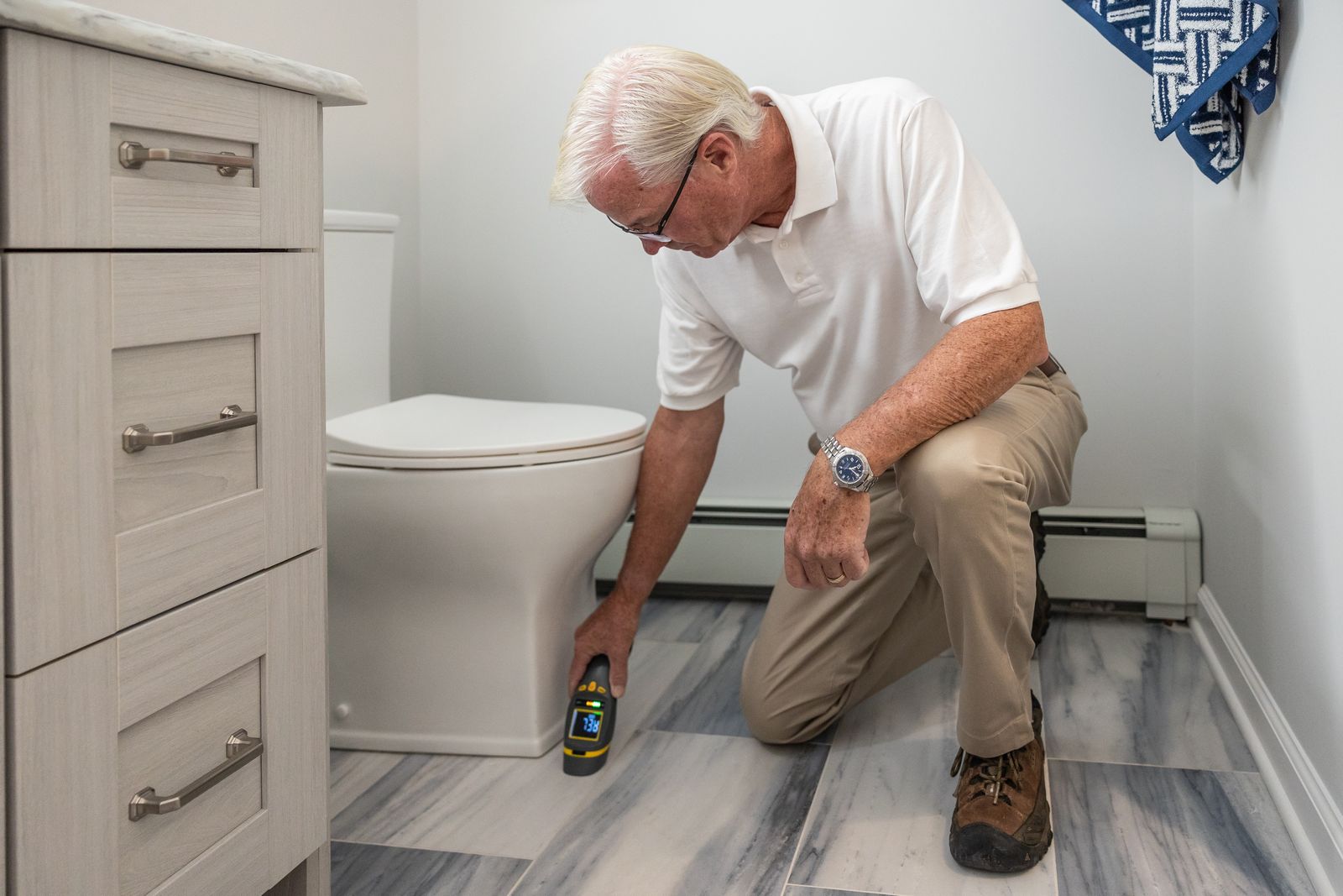Benefits Of Building Surveys Home Counties — Close-up of a surveyor examining a damp patch with a moisture meter inside a Vic Benefits Of Building Surveys Home Counties — Close-up of a surveyor examining a damp patch with a moisture meter inside a Vic