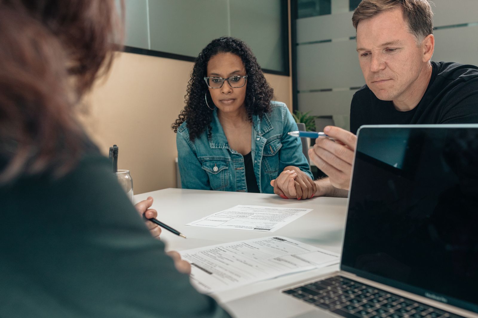 Benefits Of Building Surveys Home Counties — Surveyor and couple reviewing a detailed building survey report together at a ki Benefits Of Building Surveys Home Counties — Surveyor and couple reviewing a detailed building survey report together at a ki